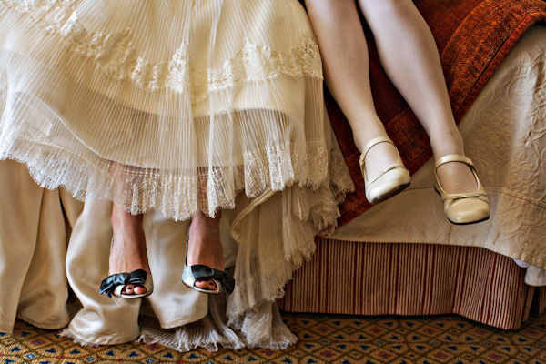 bride sitting on bed with little girl - wedding shoes - real wedding photo by Joy Marie Photography